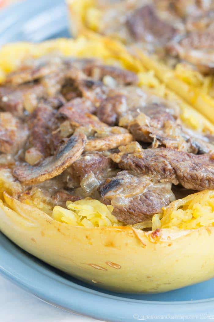 Sliced of beef with a mushroom sauce in half of a spaghetti squash