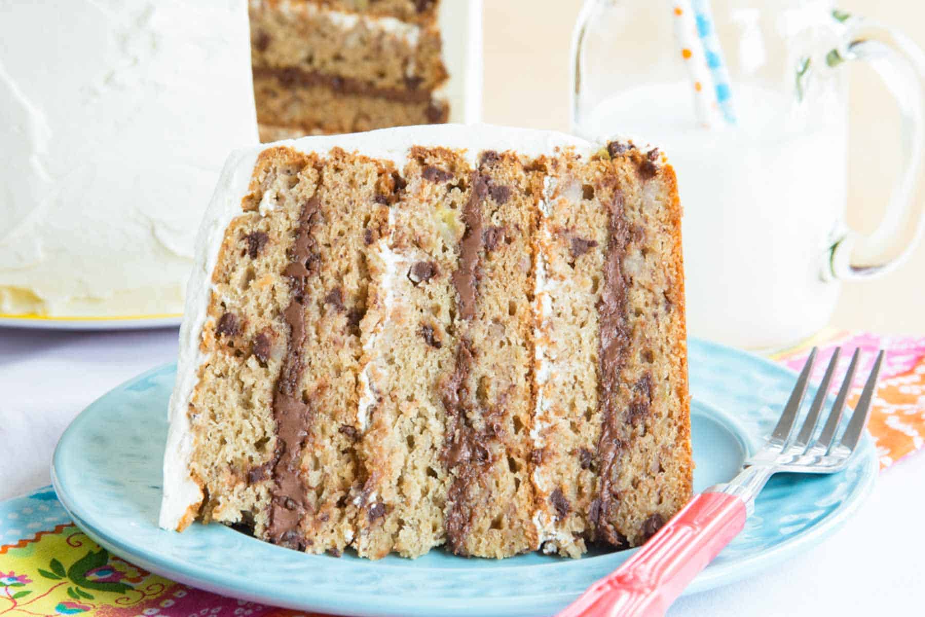 A slice of Nutella Chocolate Chip Banana Cake on a plate next to a fork