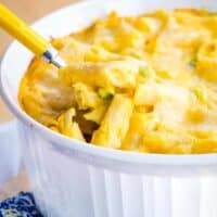 Butternut squash macaroni and cheese is spooned out of a baking dish