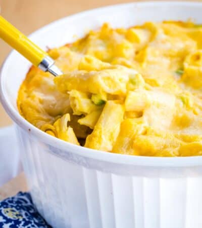 Butternut squash macaroni and cheese is spooned out of a baking dish