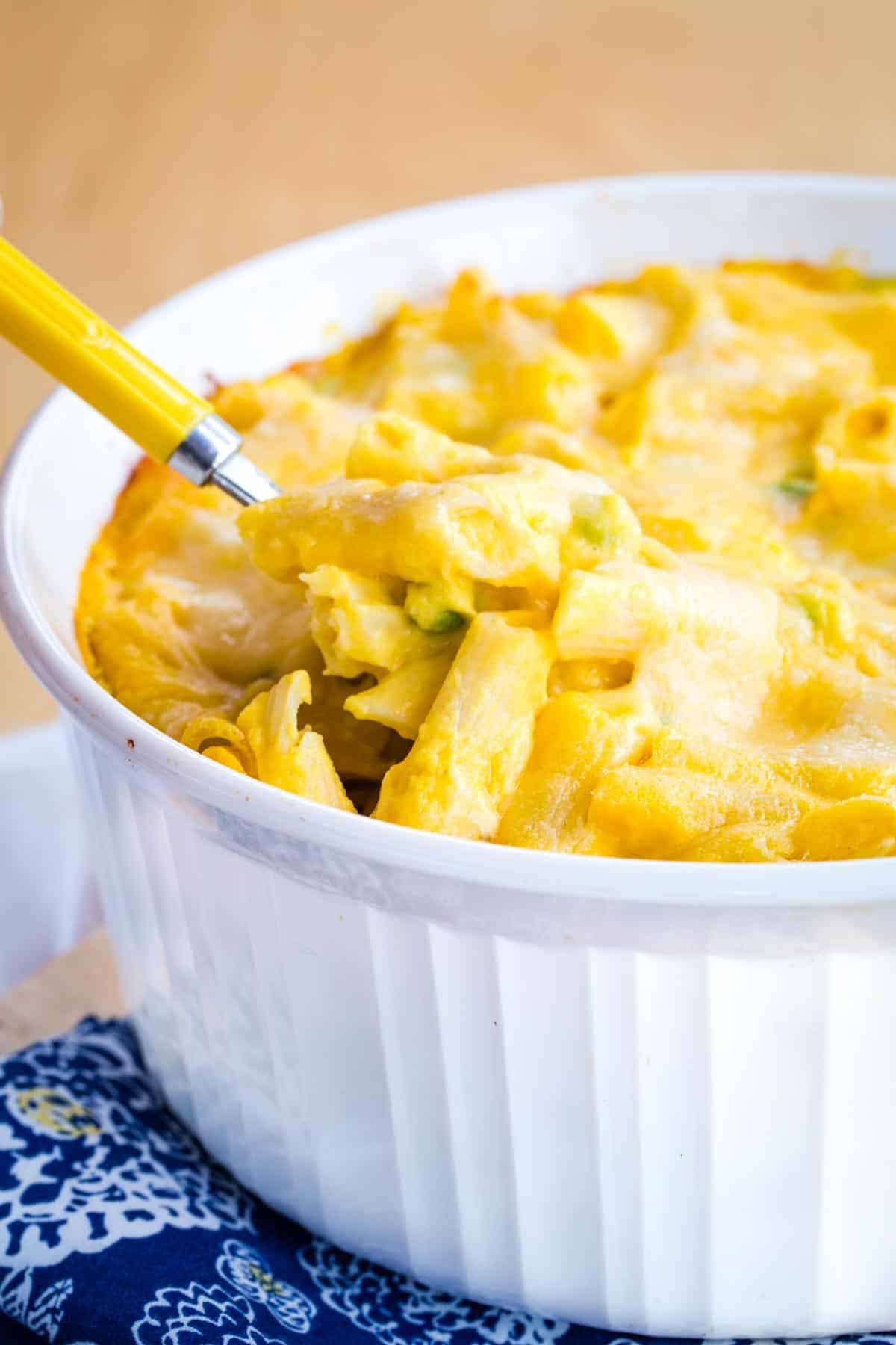 Butternut squash macaroni and cheese is spooned out of a baking dish