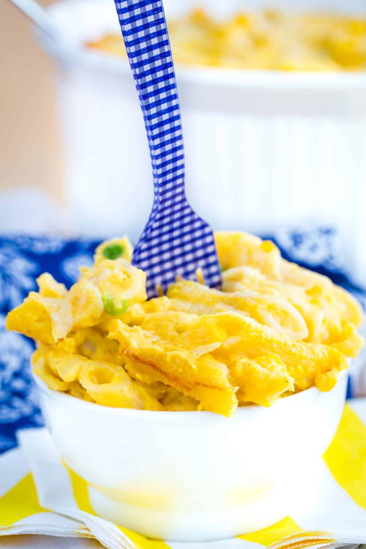 Butternut squash macaroni and cheese served in a bowl with a blue and white fork.