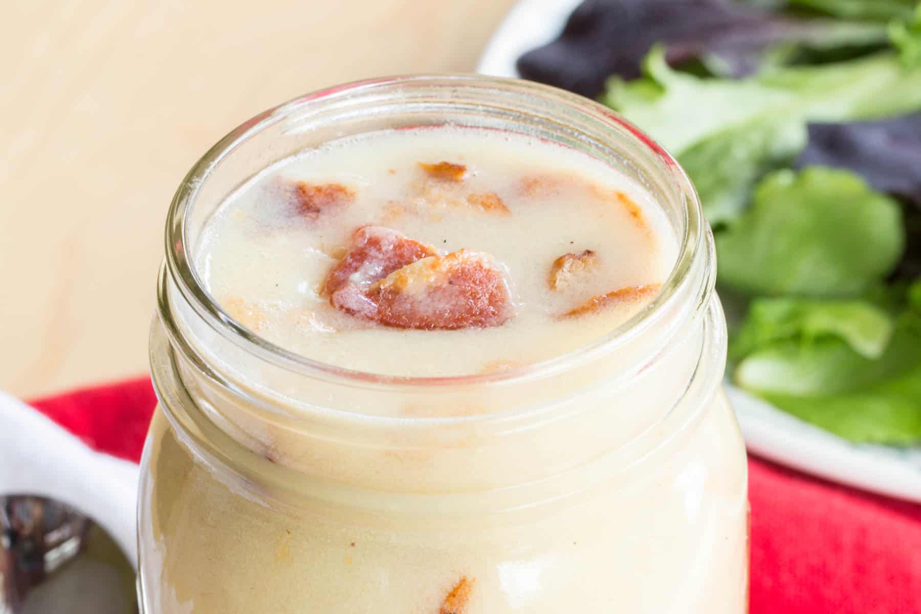 Top of a jar with Warm Bacon Dressing and bacon pieces on top