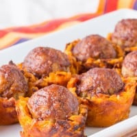 Meatballs in sweet potato cups on a platter.