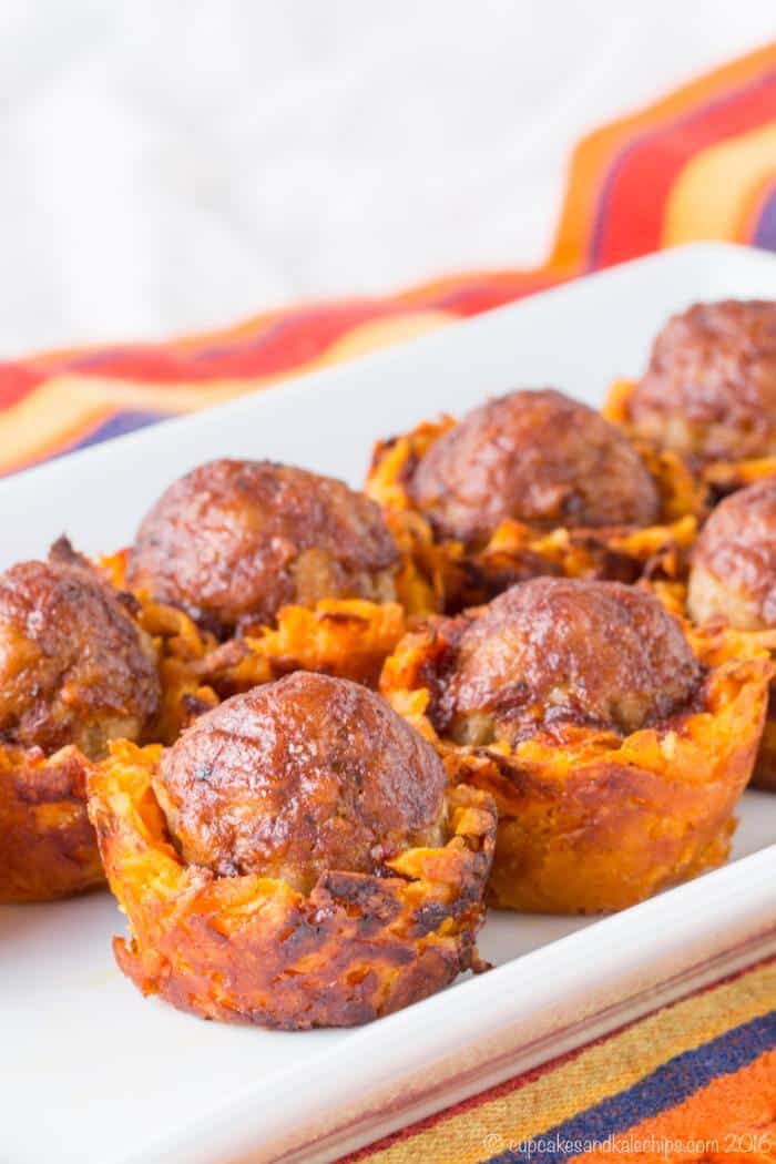 Meatballs in sweet potato cups on a platter.