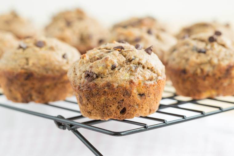 Banana chocolate chip muffins on a wire rack.