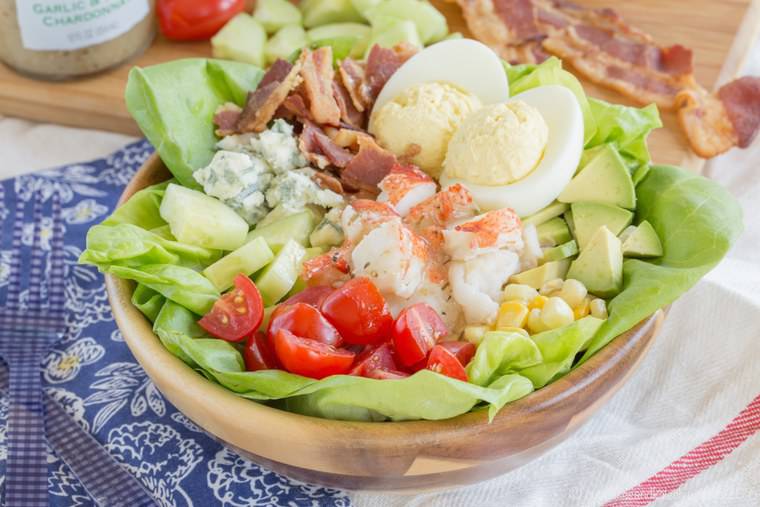 A wooden bowl with Lobster Cobb Salad