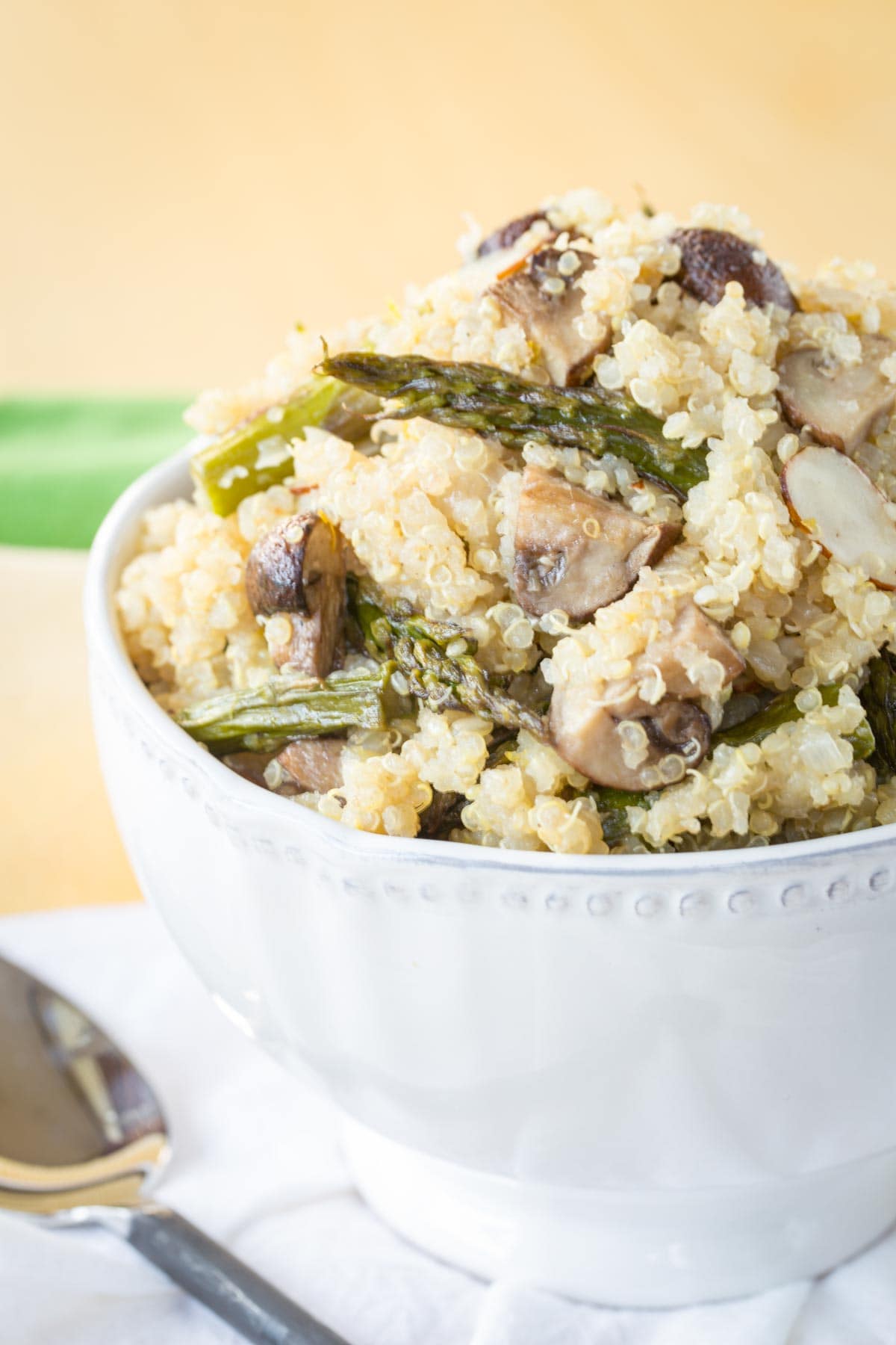 Roasted Asparagus and Mushroom Quinoa Pilaf in a white bowl with a scalloped edge