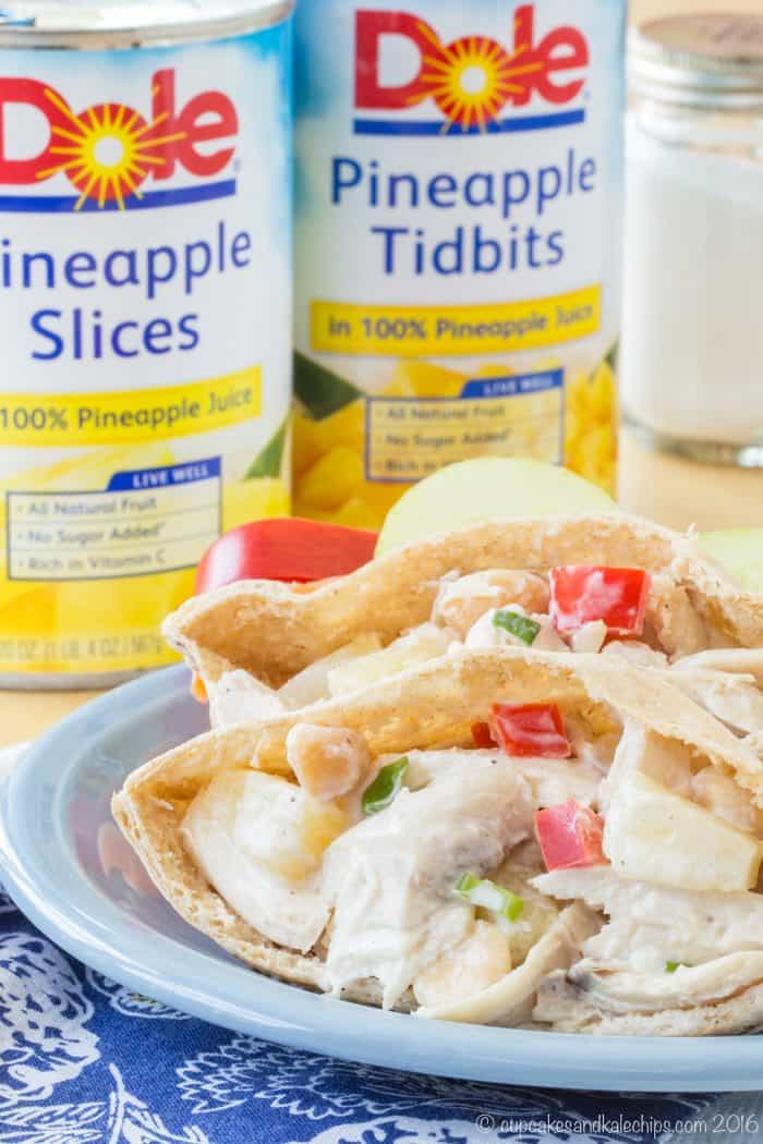 Tropical Chicken Salad on a pita with cans of Dole pineapple in the background
