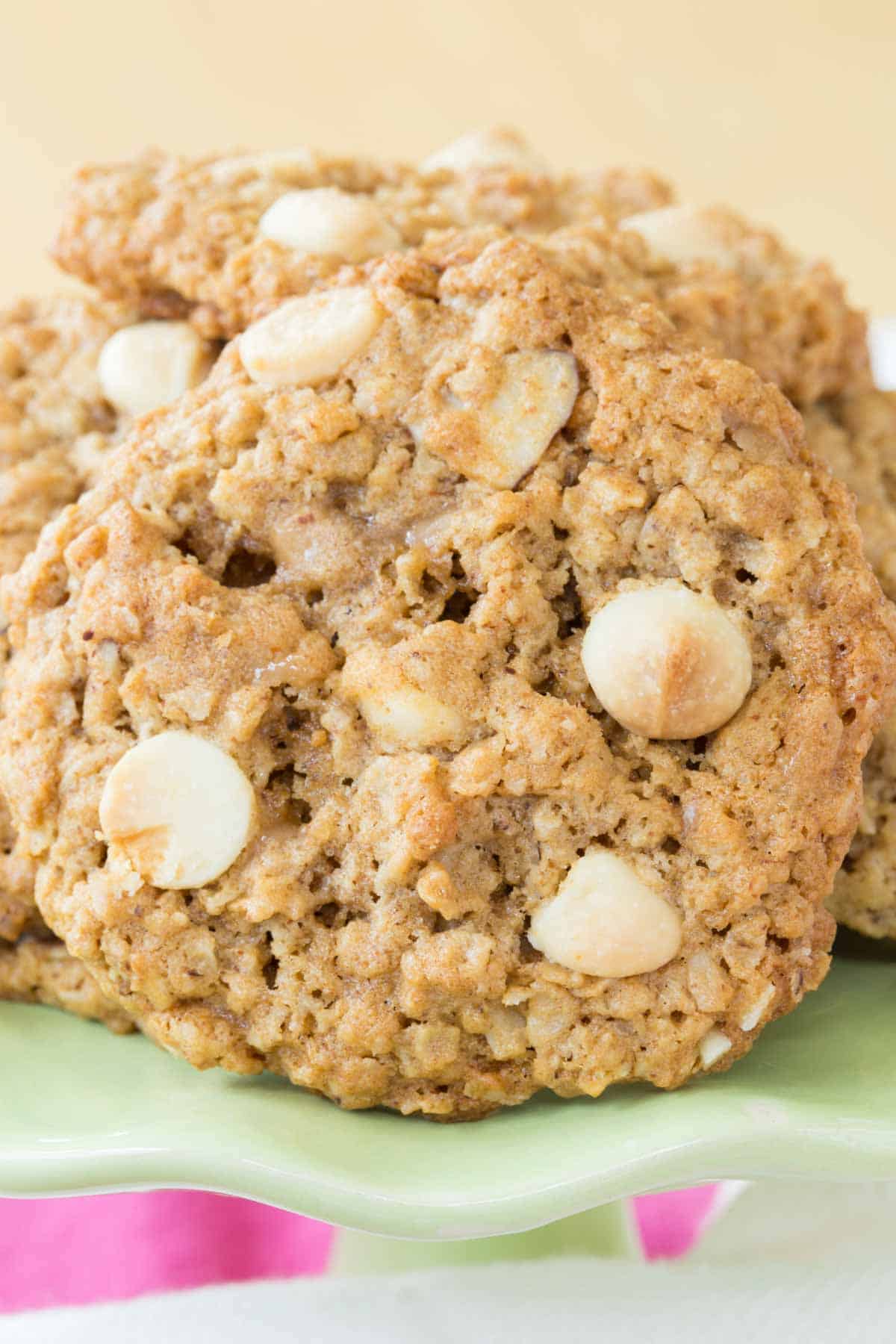 A closeup of a toffee white chocolate chip cookie on its side on a green plate.