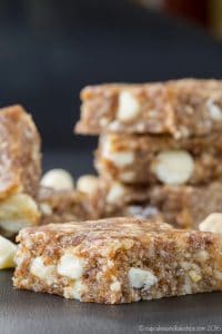 A banana caramel cashew no-bake energy bar in the foreground with a stack of bars in the background.