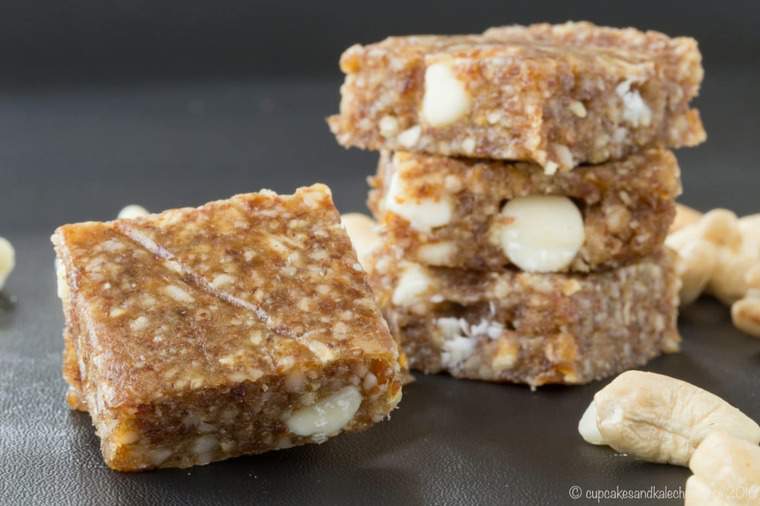 Stacks of banana caramel cashew no-bake energy bars on a grey countertop.