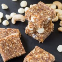 Stacks of banana caramel cashew no-bake energy bars on a grey countertop.