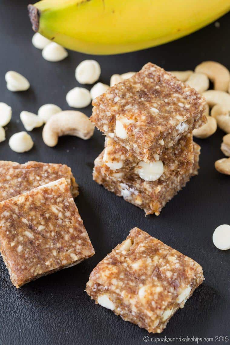 Stacks of banana caramel cashew no-bake energy bars on a grey countertop.