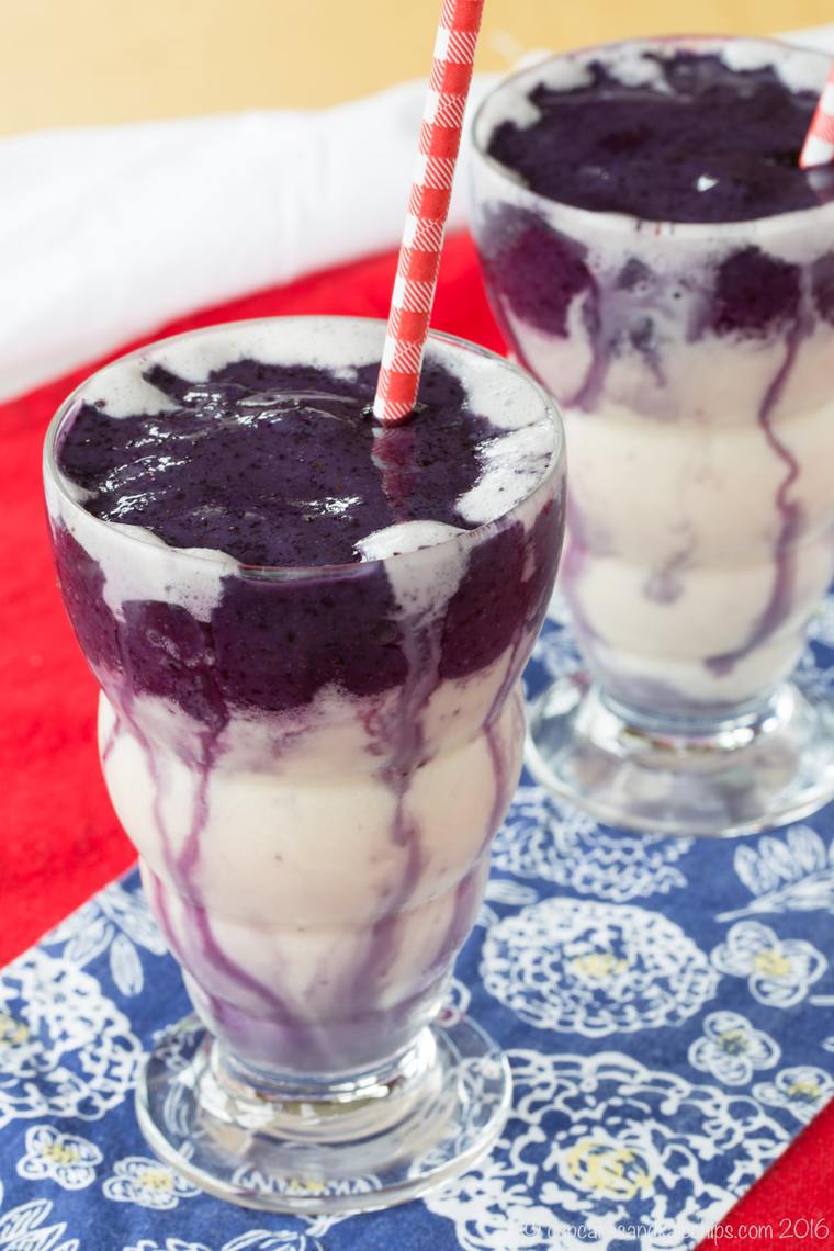 Two Honey and Vanilla Swirled Blueberry Smoothies side by side with red and white striped straws.