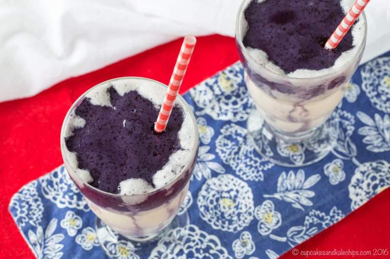 Top view of two Honey and Vanilla Swirled Blueberry Smoothies side by side with red and white striped straws.