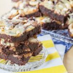 Caramel cheesecake swirl brownies stacked on a coaster.