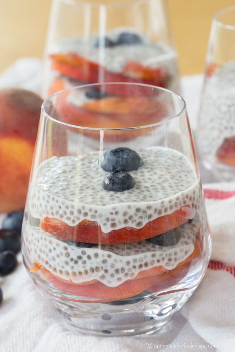 Blueberry and Peach Chia Pudding Parfaits in glasses.