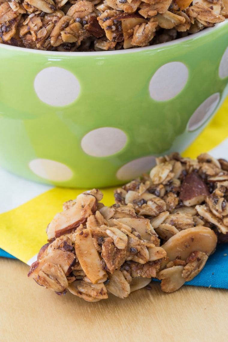 A chunky piece of granola in front of a bowl.