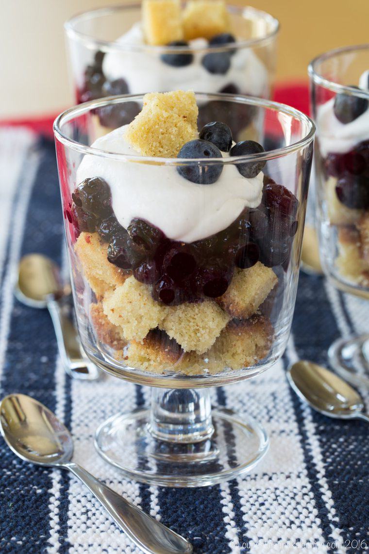 A mini blueberry and coconut cream trifle in a small glass.