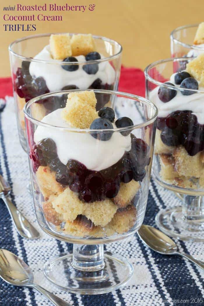 Three mini blueberry and coconut cream trifles in small glasses.