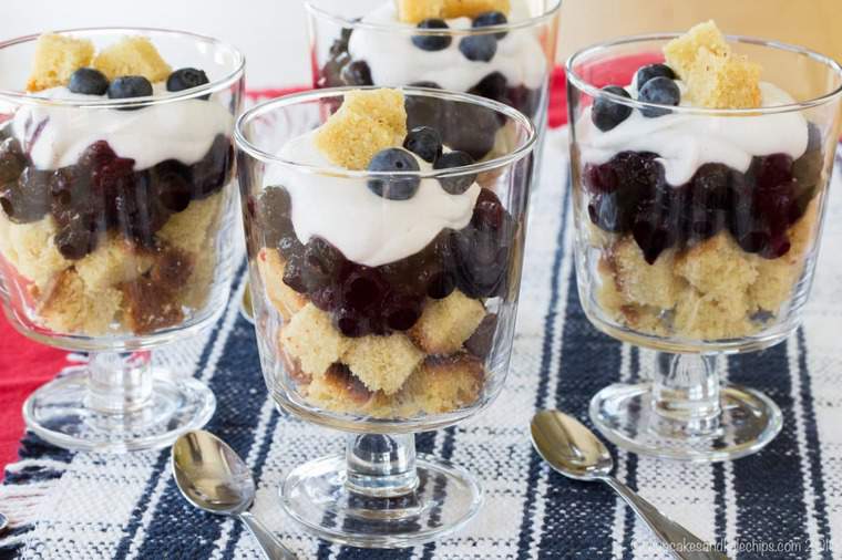 Three mini blueberry and coconut cream trifles in small glasses.