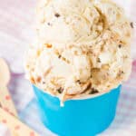A dish of ice cream with two wooden spoons next to it.