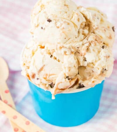 A dish of ice cream with two wooden spoons next to it.