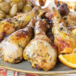 A plate with grilled chicken legs with an orange saffron marinade