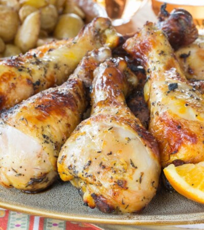 A plate with grilled chicken legs with an orange saffron marinade