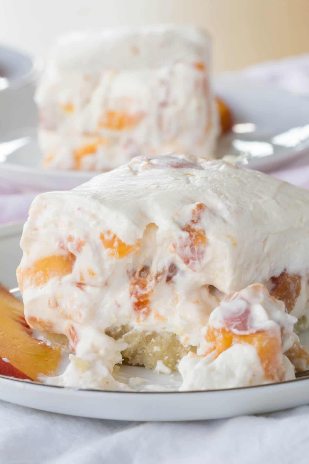 One of the No-Bake Peach Cheesecake Bars on a smal plate with a bite missing.