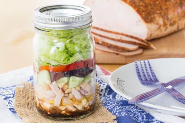 Mediterranean Turkey Mason Jar Salad - layer a simple salad dressing, feta cheese, turkey, veggies, and more for an easy and portable lunch recipe with @jennieorecipes. Gluten free and low carb. #ad | cupcakesandkalechips.com