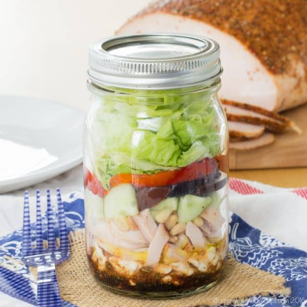 Mediterranean Turkey Mason Jar Salad - layer a simple salad dressing, feta cheese, turkey, veggies, and more for an easy and portable lunch recipe with @jennieorecipes. Gluten free and low carb. #ad | cupcakesandkalechips.com