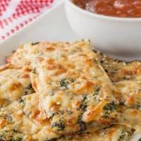 spinach artichoke cauliflower breadsticks stacked on a plate