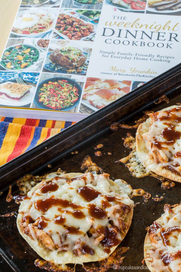 The tostadas on a baking sheet with The Weeknight Dinners Cookbook in the background.