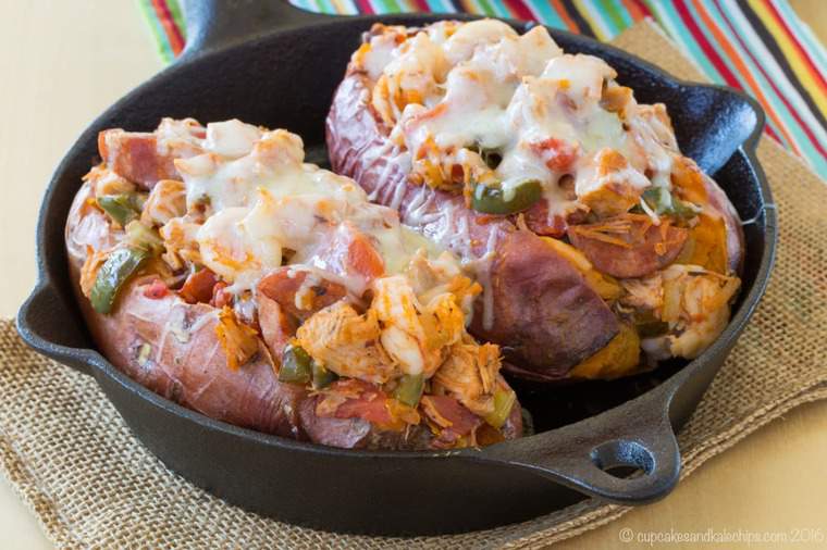 Two jambalaya stuffed baked sweet potatoes in a skillet.