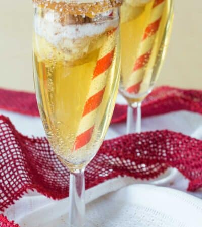Two flutes of sparkling cider with a small scoop of ice cream floating in them.