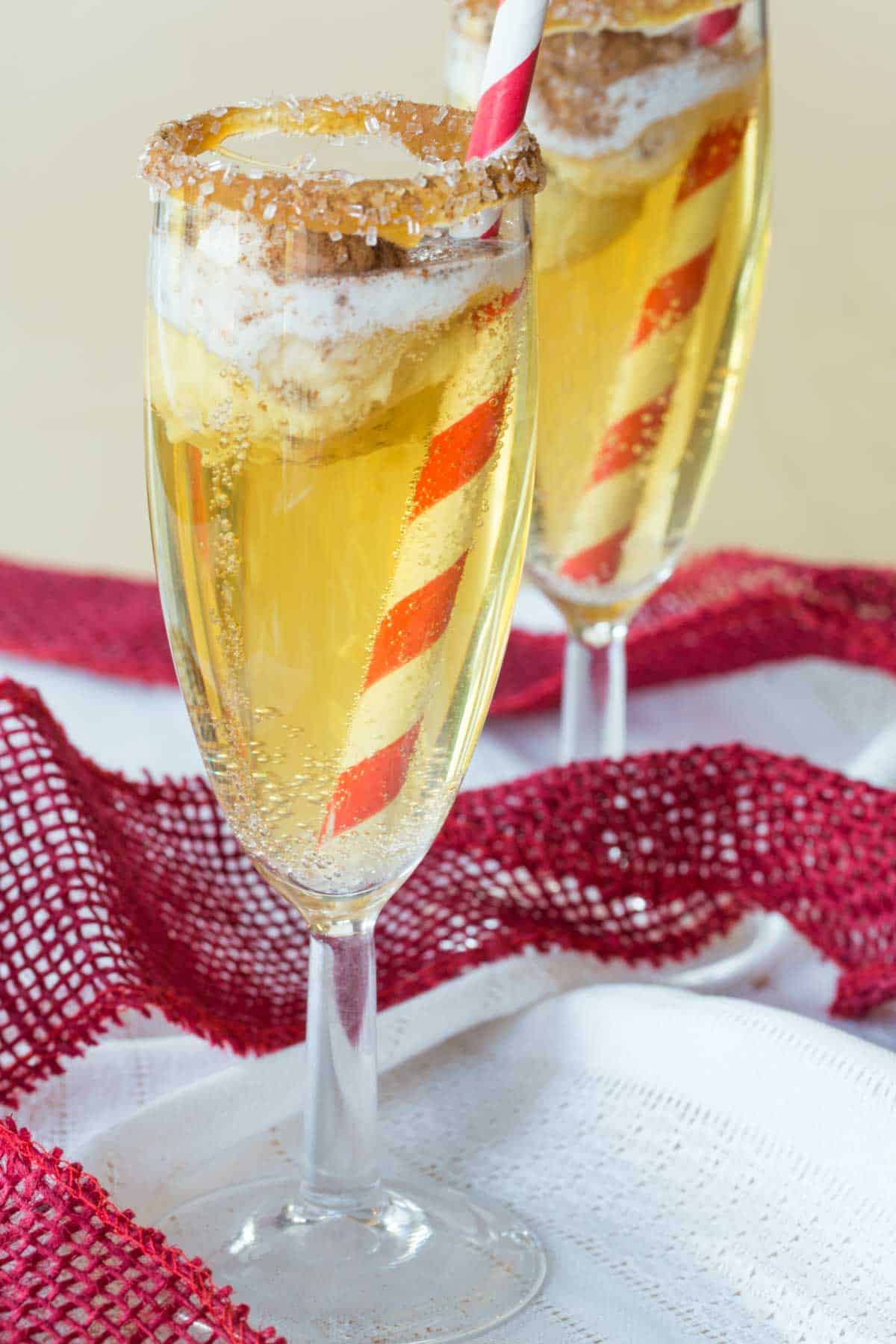 two flutes of sparkling cider with a small scoop of ice cream floating in them