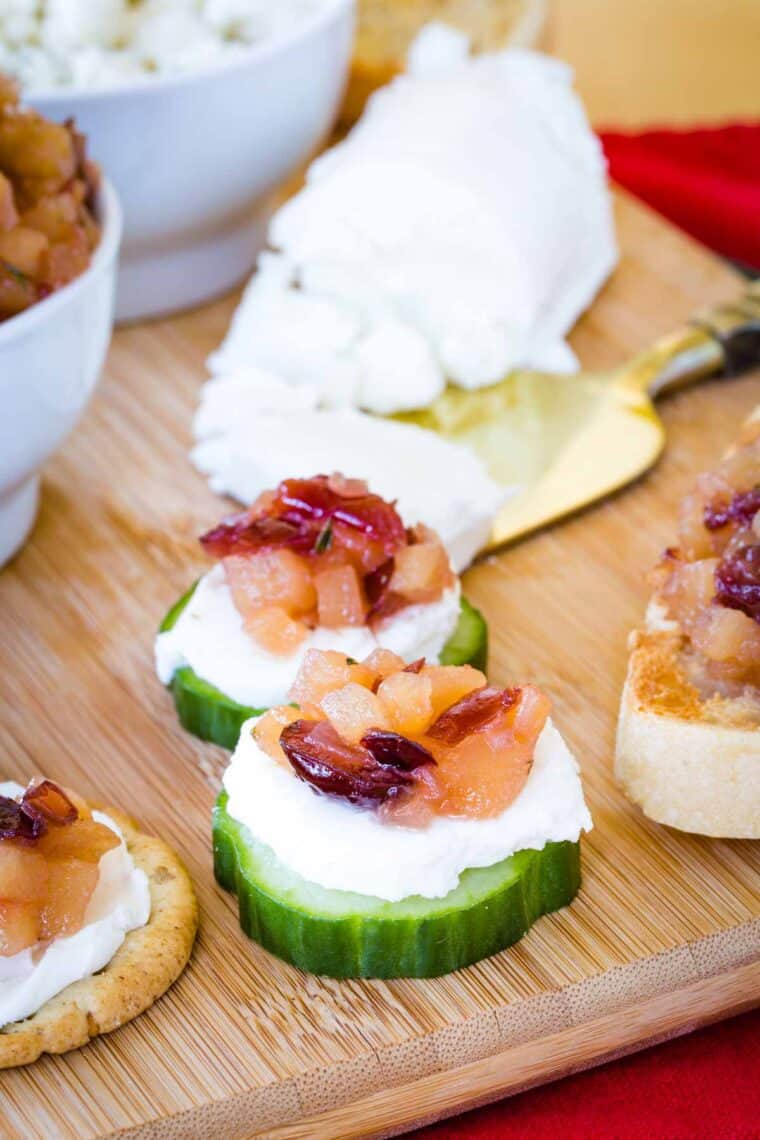 Two cucumber sliced topped with goat cheese and apple chutney.
