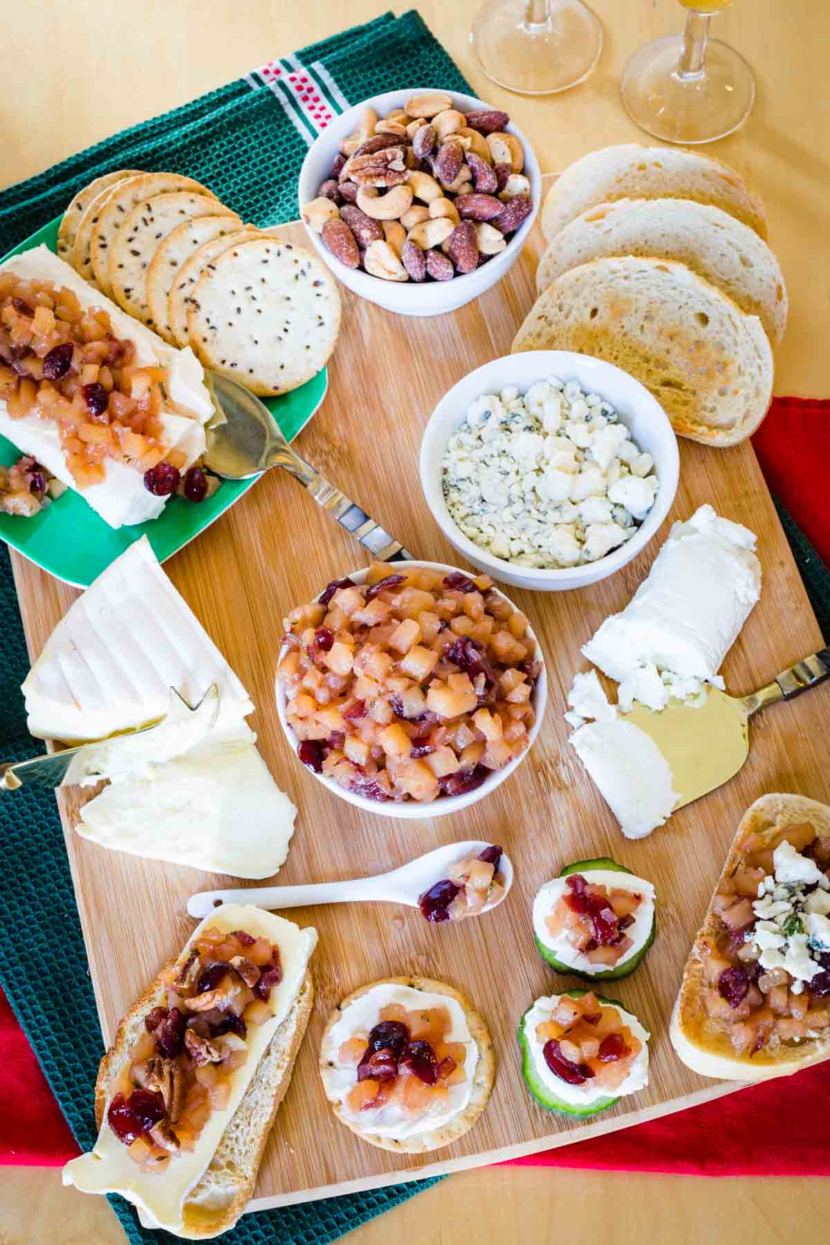 Looking down at a cheeseboard with crackers, bread, and other accompaniments.