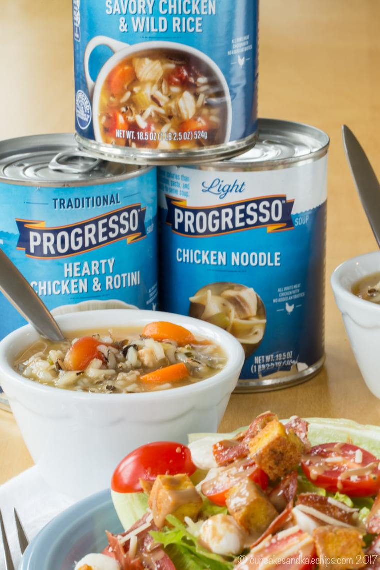 Cans of Progresso soup and a bowl of chicken wild rice soup served with a wedge salad