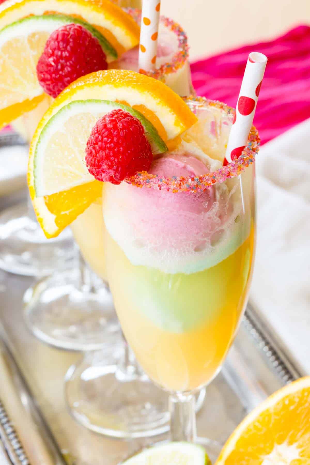 A Rainbow Sherbet Float Garnished with a Lime Slice, an Orange Slice and a Raspberry