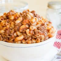 Classic Beefaroni in a white bowl with a red and white napkin