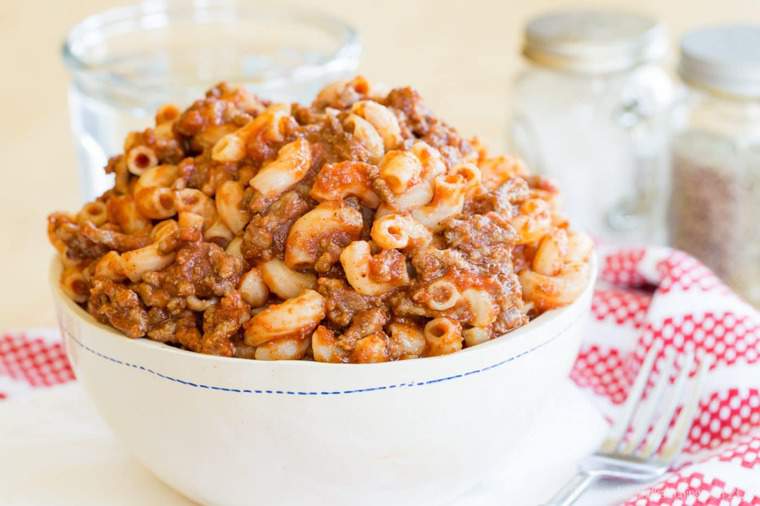 Classic Beefaroni in a white bowl with a red and white napkin