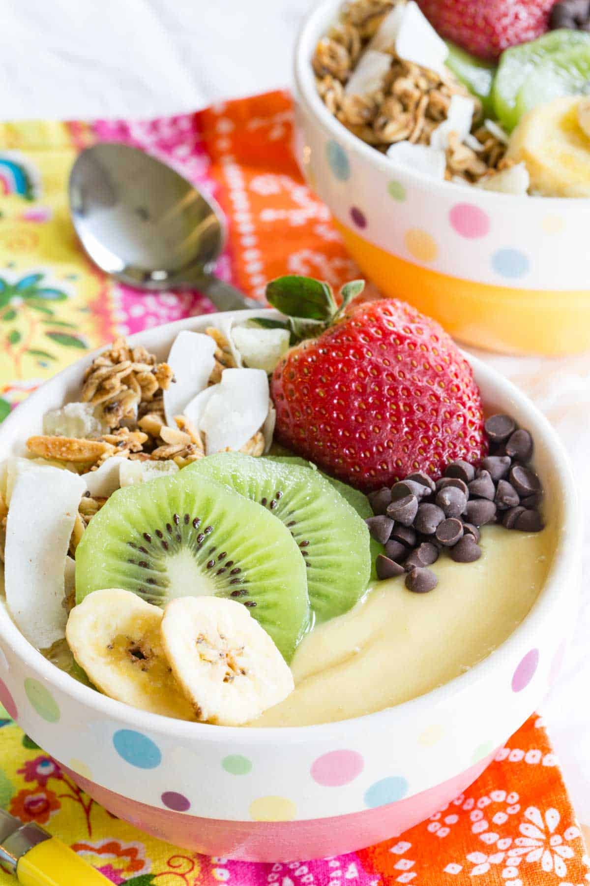 Tropical Smoothie Bowl topped with fresh fruit, chocolate chips, and granola