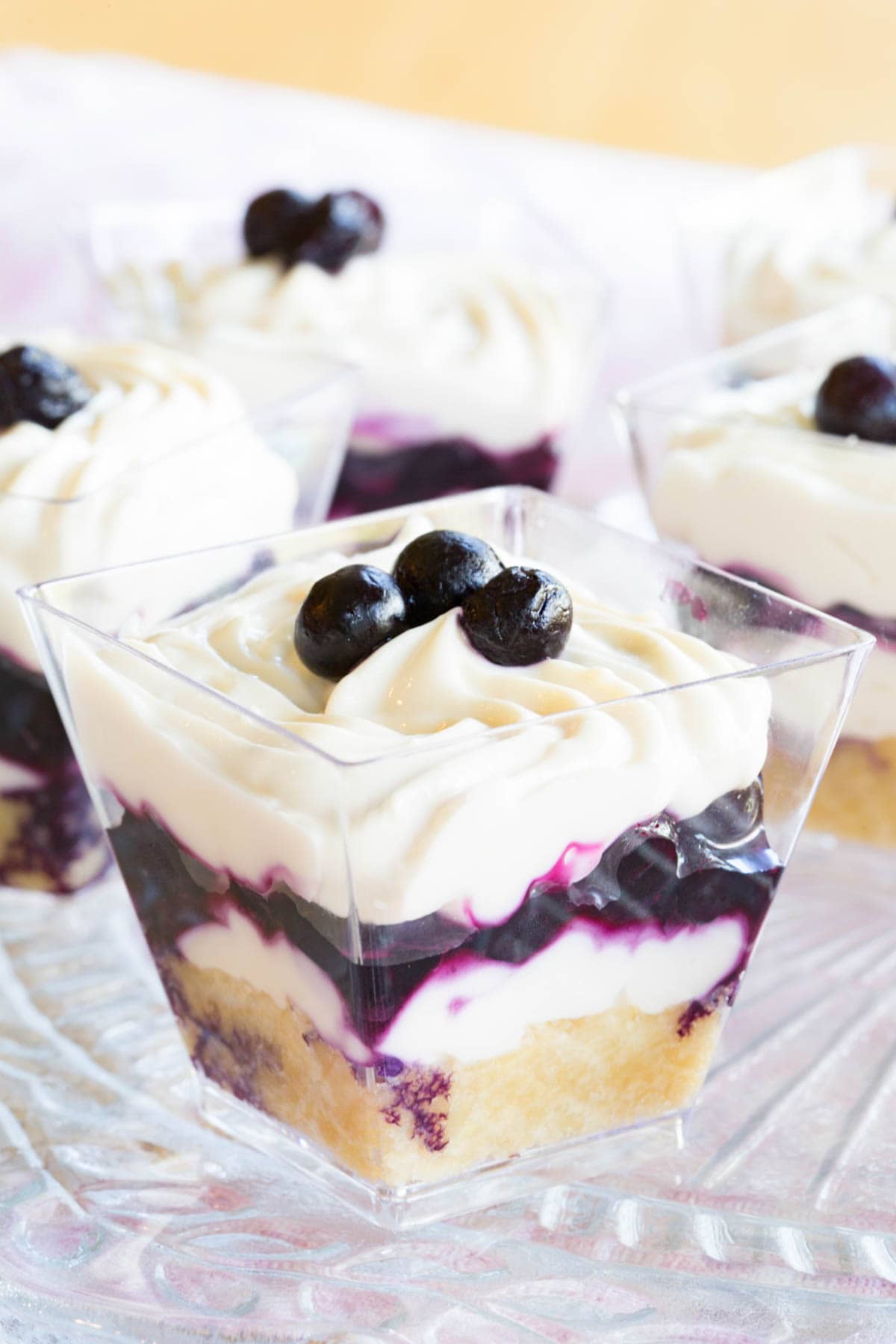 Blueberry Maple Mini Cheesecake Parfaits on a platter with one closeup in the foreground.