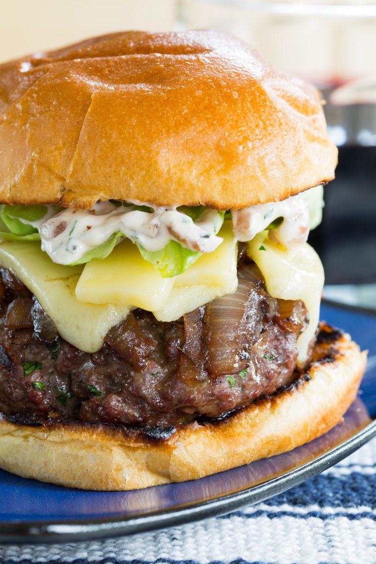 French Onion Stuffed Hamburger with Gruyere cheese and caramelized onion aioli on a brioche bun