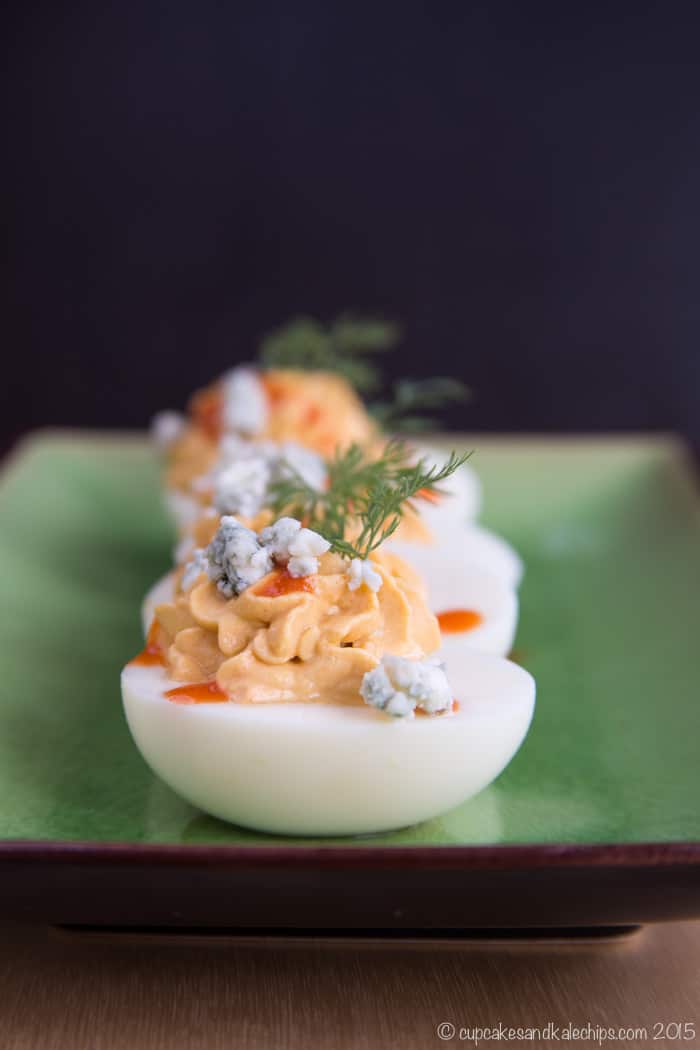 Buffalo Blue Cheese Deviled Eggs on a green rectangular plate for serving