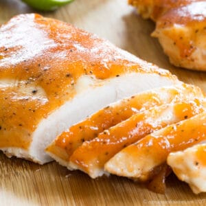 Sliced glazed turkey breast tenderloin on a wooden cutting boards.
