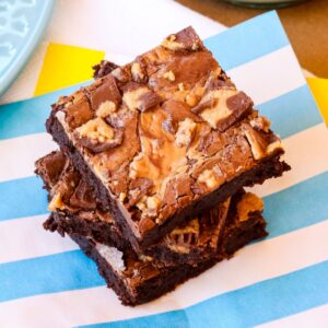 Three stacked Reese's Brownies on a blue and white striped napkin.